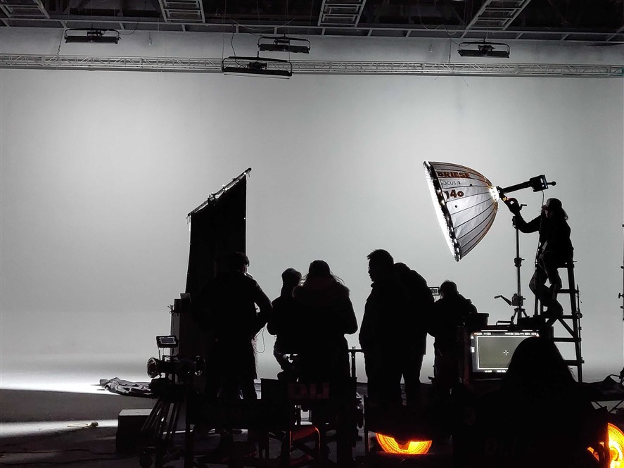 Indoor Guangzhou production setup with crew, lighting, and camera gear on a studio stage